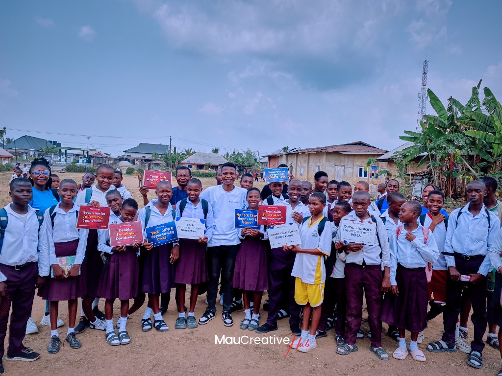 Students at Government Migrant Technical College, Akpabuyo, holding tech motivation signs during a Mau Creative Hub outreach day