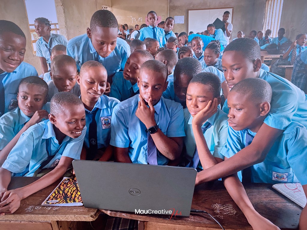 Students at Jordan the Seed Foundation School gathered around a laptop during a Mau Creative Hub outreach session
